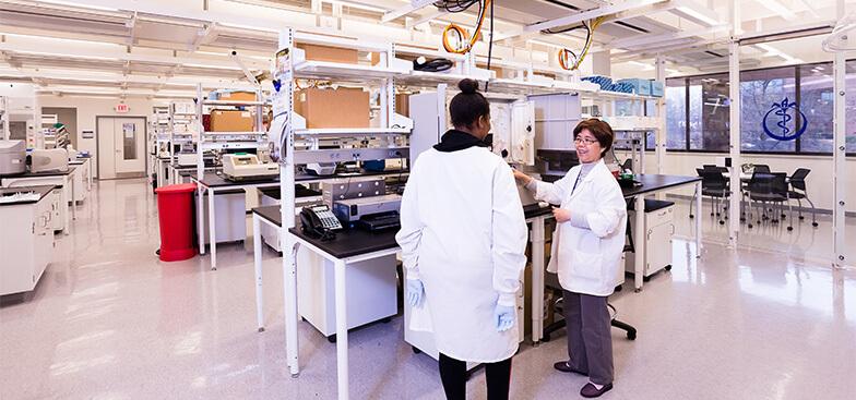 two women standing inside a lab room