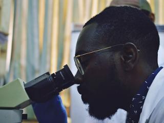 a man looks into a microscope
