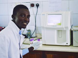 a man smiles while using lab testing equipment